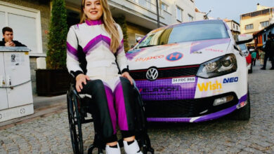 Fotoğrafta, Kübra Denizci Keskin tekerlekli sandalye üzerinde ve arkasında ise bir ralli aracı var.