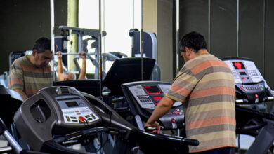 Fitness salonunda bir kişi koşu bandının üzerinde koşuyor.