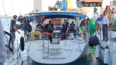 Fotoğrafta yer alan bir teknenin içinde insanlar yer alıyor ve tekneyi hareket ettirmek için hazırlanıyorlar.