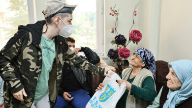 Fotoğrafta, zihinsel yeti kaybı olan engelli bireyler, huzurevinde kalan yaşlı bireylere hediye veriyor.