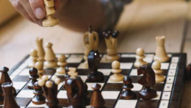 Fotoğrafta, bir masa üzerinde satranç tahtası ve satranç taşları var. Fotoğraftaki satranç oyununda beyaz ve siyah taşlar biraz hareket ettirilmiş oyunun ileriki bir aşaması olduğu anlaşılmaktadır.