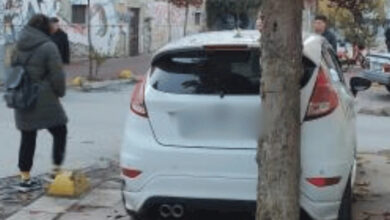 Beyaz renkli bir otomobil kaldırımın üzerine park edilmiş. Park edilen otomobil engelli rampasının tam önünde duruyor.