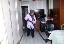 Fotoğrafta, Kepez Belediyesi'nin evde sağlık hizmeti ekibinin temizlik konusunda da destek olduğu görülüyor. Görevlinin elinde elektrikli süpürge ile evi süpürüyor.