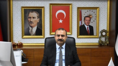 Niğde İŞKUR İl Müdürü Ali Bingül, makam koltuğunda oturuyor ve önündeki masa üzerine birçok obje var.