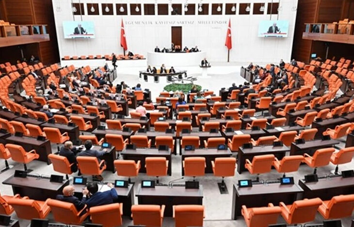 TBMM’nde arka taraftan geniş bir açıyla çekilmiş bir fotoğraf. Fotoğrafta milletvekillerinin oturduğu alanlar ve meclis kürsüsü yer alıyor.