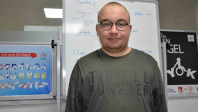 Beyaz tahtaya sırtı dönük bir şekilde duran engelli birey Muhammed Emir Ertuğrul'un kameraya doğru bakarak röportaj gerçekleştirdiği görülmektedir.