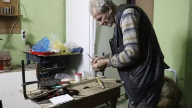 Fotoğrafta, Parkinson hastası Ahmet Yetim tezgah üzerine kurduğu sistem ile tahta malzemeleri kullanarak ev maketi yapıyor.