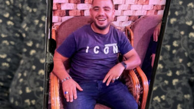 Fotoğrafta, zihinsel engelli birey Ahmed Mesalme'nin eski bir fotoğrafı bir kişinin yakasında asılı şekilde duruyor.