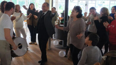 Fotoğrafta, engelli bireyler ve ailelere müzik eşliğinde oyun havası oynuyorlar.