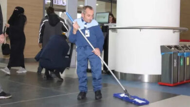 Fotoğrafta, engelli birey elindeki paspas ile temizlik yapıyor. Engelli bireyin üzerinde temizlik personeli kıyafeti var ve hastanenin temizlik personeli olarak istihdam ediliyor.
