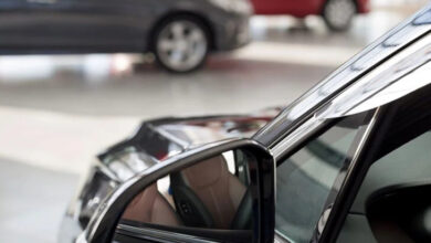 Fotoğrafta, bir otomobilin aynasından içi gözüküyor ve otomobilin karşısında ise başka otomobiller var.
