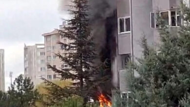 Fotoğrafta, bir apartmanın dışarısından çekildiği görülmektedir. Apartmanın bir dairesinde alevler yükselmekte ve siyah dumanlar ortaya çıkarmaktadır.