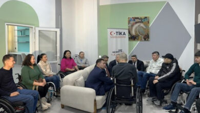 Fotoğrafta tekerlekli sandalye kullanan engelli bireyler ve açılış için katılım sağlayan görevli kişiler karşılıklı bir şekilde sohbet ediyorlar.