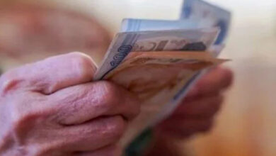 Fotoğrafta, yaşlılıktan dolayı elleri üzerinde kırışıklıklar olan bir kişi sadece para sayarken elleri gözüküyor.