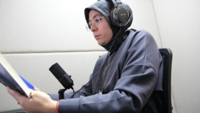 Esenyurt Belediyesi'nin sesli kitap projesi için bir kadın stüdyo ortamında elindeki kitabı seslendiriyor.