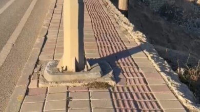 Fotoğrafta, kaldırımda yer alan görme engelli bireylerin kullandığı rehber yolun yanında elektrik direği var.