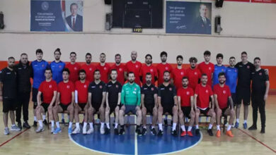 Görselde, kırmızı ve siyah formalar giymiş bir grup erkek sporcu ve teknik ekip, bir spor salonunda toplu halde poz veriyor. İşitme Engelli Erkek Futsal Milli Takımı’nın, Sırbistan'daki Avrupa Şampiyonası eleme maçları için Aksaray'da yaptığı hazırlıkları yansıtan bir kare.