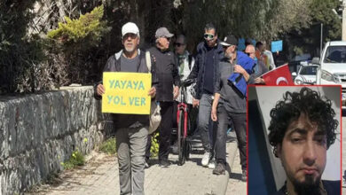 Fotoğrafta, bir grup insan kaldırımda yürüyerek farkındalık etkinliği düzenliyor. Ön sırada beyaz şapkalı bir adam, elinde sarı üzerine mavi harflerle yazılmış "YAYAYA YOL VER" pankartını taşıyor. Arkasında çeşitli yaş gruplarından kişiler bulunuyor; bazıları yürüyerek, bazıları bisikletleriyle ilerliyor. İçlerinden biri Türk bayrağı taşıyor. Yolun kenarında taş bir duvar ve yeşillikler yer alırken, arka planda araç trafiği görülüyor. Sağ alt köşede ise sakallı ve kıvırcık saçlı bir adamın portresi eklenmiş.