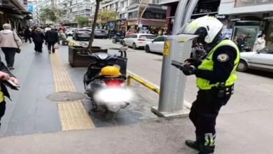 Memur motosikletin yanında cezai işlem uyguluyor.