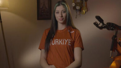 Paralimpik atlet Reyhan Taşdelen beyaz renkli Türkiye yazılı kırmızı tişörtle poz veriyor.