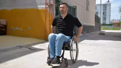 Sezgin Keşto, tekerlekli sandalye kullanarak sokakta geziyor.