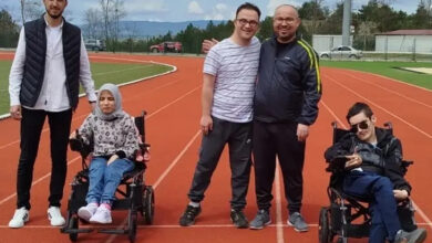 Bu fotoğraf, Kastamonu Üniversitesi'nde gerçekleştirilen anlamlı bir sosyal etkileşim projesine ait. Bir spor pistinde çekilmiş karede, tekerlekli sandalyedeki bireylerle birlikte gönüllü öğrenciler yer alıyor. Hep birlikte gülümseyerek verdikleri poz, kampüs ortamında engelli bireylerle kurulan sıcak dostluğu ve dayanışmayı yansıtıyor.