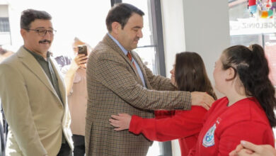 Kütahya Valisi Musa Işın, kendisine sarılan personel kızın omuzlarından tutuyor.