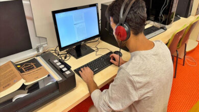 Bilgisayar başında oturan erkek öğrenci kulaklık takarak seslendirme yapıyor.