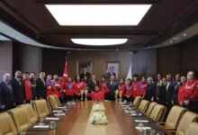 Gençlik ve Spor Bakanı Dr. Osman Aşkın Bak ile Özel Sporcular Para Atletizm Milli Takımı makam odasında hatıra fotoğrafı çektiriyor.