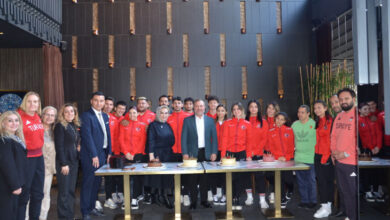 Türkiye Özel Sporcular Spor Federasyonu Yönetim Kurulu Üyesi ve iş insanı Sayın Nuray Yılmaz, Başkan Birol Aydın, üyeler ile Özel Sporcular Para Atletizm Milli Takımı, pastaların olduğu etkinlik masası başında poz veriyor.