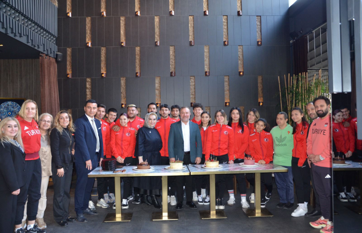 Türkiye Özel Sporcular Spor Federasyonu Yönetim Kurulu Üyesi ve iş insanı Sayın Nuray Yılmaz, Başkan Birol Aydın, üyeler ile Özel Sporcular Para Atletizm Milli Takımı, pastaların olduğu etkinlik masası başında poz veriyor.