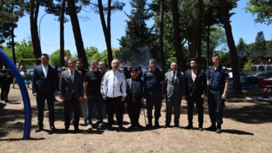 Bu görselde, 10-16 Mayıs Engelliler Haftası kapsamında Orhangazi’de düzenlenen bir etkinlikten kare yer alıyor. Açık havada, çam ağaçları arasında çekilmiş bu fotoğrafta, farklı kurum ve meslek gruplarından insanlar yan yana dizilmiş şekilde poz veriyor. Aralarında takım elbise giymiş kamu görevlileri, üniformalı emniyet mensupları ve sivil bireyler bulunuyor.