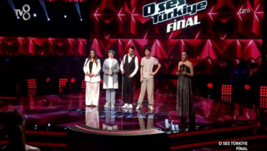 Görme engelli finalist Mert Özer ve diğer ikisi kadın, bir erkek yan yana yarışma sahnesinde bulunuyor.