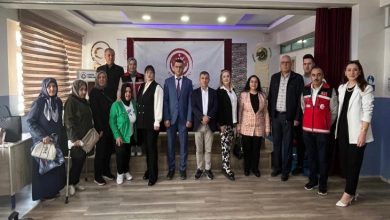 Farklı yaş gruplarından oluşan kadın ve erkekler ayakta bir şekilde fotoğrafta yer alıyor.