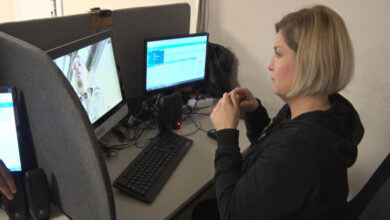 Kadın personel işaret diliyle bilgisayar ekranında bulunan erkekle çevrimiçi iletişim kuruyor