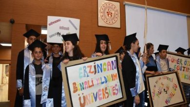 Özel öğrenciler mezuniyet kıyafetleri ve ellerindeki pankartlarla sahnede bulunuyor.