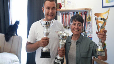 Anne Gülnur Tunca ve sporcu oğlu Tuna Tunca ellerinde kupaları tutuyor.