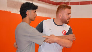Fotoğrafta, turuncu renkli arka planına sahip kapalı bir spor salonu olduğu düşünülen yerde tekvando yapan 2 erkek görülmektedir. İçlerinden yaşça büyük olduğu düşünülen eğitmen öğrencisine özel bir teknik göstermektedir.