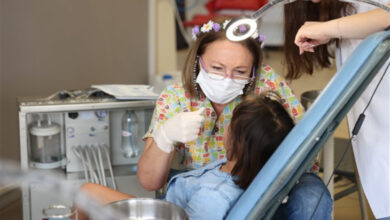 Kadın doktor tarafından diş muayenesi yapılan çocuk.