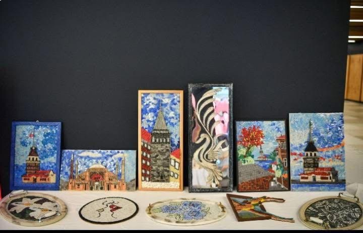 İstanbul'un tarihi yerlerini temsil eden tablolar ile el sanatı eserler masada bulunuyor.