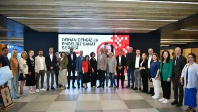 Sergi salonunda engelliler, yetkililer ve katılımcılar beraber anı fotoğrafı çektiriyor.