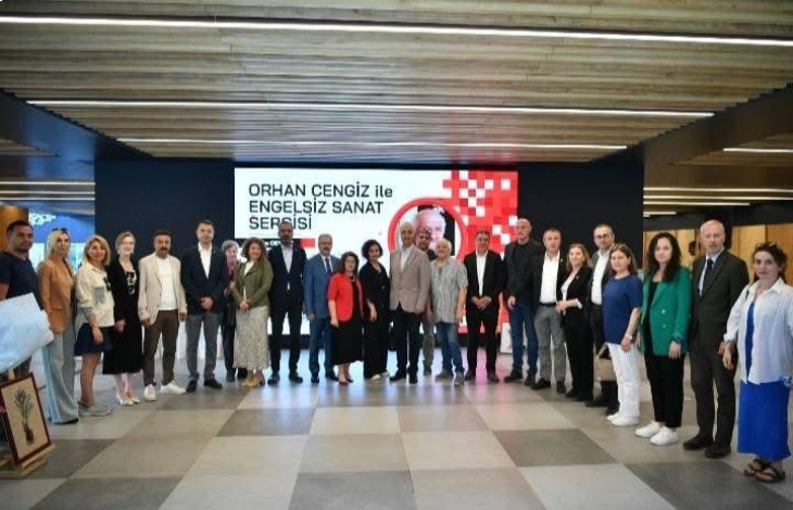 Sergi salonunda engelliler, yetkililer ve katılımcılar beraber anı fotoğrafı çektiriyor.