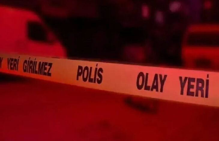 Bu görselde, sarı renkli “POLİS OLAY YERİ – GİRİLMEZ” yazılı emniyet şeridi yer alıyor. Şerit, bir olay yerinin çevresini güvenlik amacıyla kapatmak için kullanılıyor. Arka plan kırmızı ağırlıklı ışıkla aydınlatılmış, muhtemelen gece çekilmiş bir sahne; arkada silüet hâlinde araçlar ve belirsiz yapılar görünüyor.