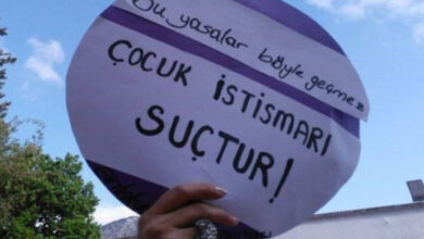 Fotoğrafta bir kişi, “Bu yasalar böyle geçmez – Çocuk istismarı suçtur!” yazılı bir pankart tutuyor. Görsel, çocuk istismarına karşı toplumsal farkındalık ve hukukî yaptırımlar çağrısı içeren bir protesto ya da farkındalık etkinliğinden alınmış.