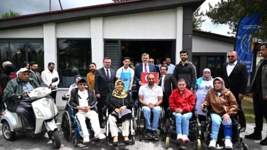 Erzurum Valisi Mustafa Çiftçi ile engelliler, Türkiye Sakatlar Derneği hizmet binası önünde hatıra fotoğrafı çektiriyor.