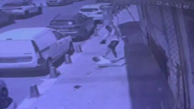 Görselde, kaldırımda yere yatmış şekilde duran bir çocuk ve yaşça daha büyük bir erkek tekme atarak yerde yatan kişiyi darp ediyor.