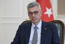 Fotoğrafta Sağlık Bakanı Kemal Memişoğlu yer alıyor. Bakanın arkasında ise Türk bayrağı ile Sağlık Bakanlığı'nın logosunu taşıyan bir bayrak görülüyor."