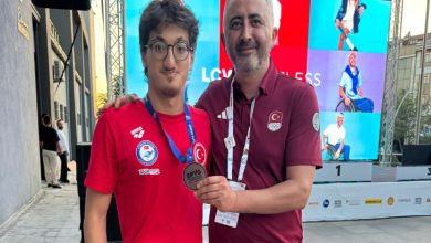 Para Yüzme Milli Takım antrenörü Çetin Koçak, Paralimpik Milli Yüzücü Turgut Aslan Yaraman'ın boynundaki madalyayı tutarak poz veriyorlar