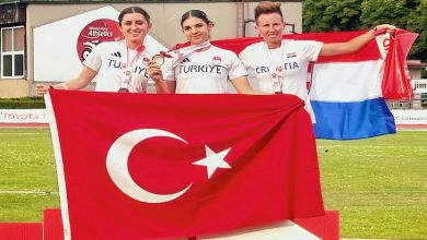 Görselde, uluslararası bir atletizm turnuvasında madalya kazanan üç kadın sporcu kürsüde poz veriyor. Ortada iki Türk milli sporcu, "TÜRKİYE" yazılı formalarıyla Türk bayrağını gururla tutarken, biri altın madalyasını gösteriyor. Sağda ise Hırvatistan’ı temsil eden bir sporcu kendi bayrağıyla yer alıyor. Arka planda “World Para Athletics” logosu görülüyor.