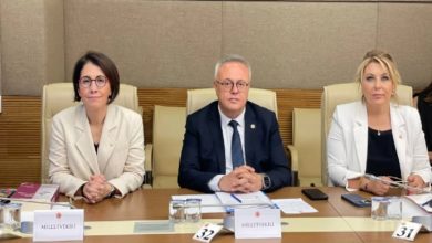 Bu görselde, Türkiye Büyük Millet Meclisi’nde (TBMM) düzenlenen bir komisyon toplantısında üç milletvekili yer alıyor. Ortam resmi ve ciddi bir toplantı salonunu andırıyor. Masada “Milletvekili” yazılı kartlar, numaralandırılmış koltuklar, evraklar, su bardakları ve belgeler dikkat çekiyor.